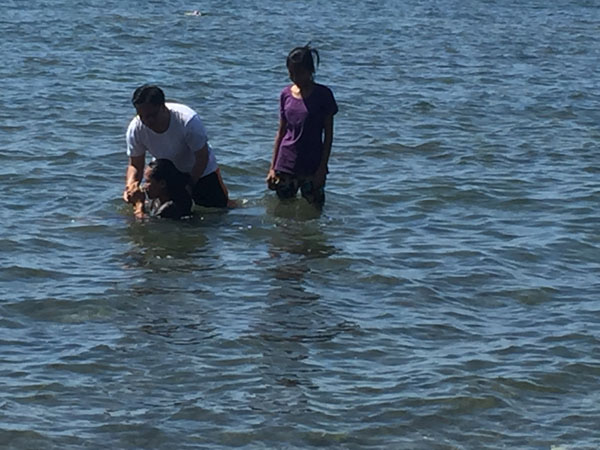 mother and niece  being baptised in South China Sea